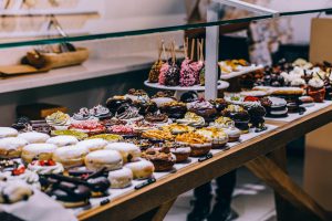 A tempting display of various donuts and pastries in a bakery. Ideal for food lovers and culinary enthusiasts.